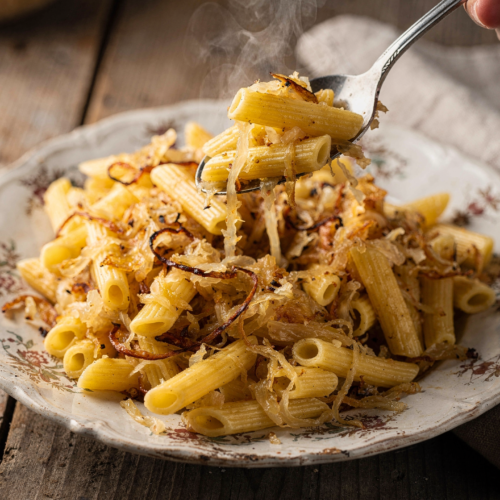 Finished makaróni káposztával plated in a traditional Hungarian style with a spoon showing the tender texture