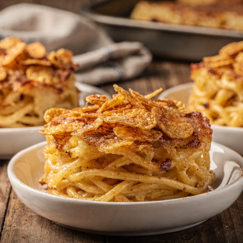 Golden-brown Easy Baked Sweet Noodle Puddings kugel-style bake fresh from the oven with cinnamon and cornflake topping